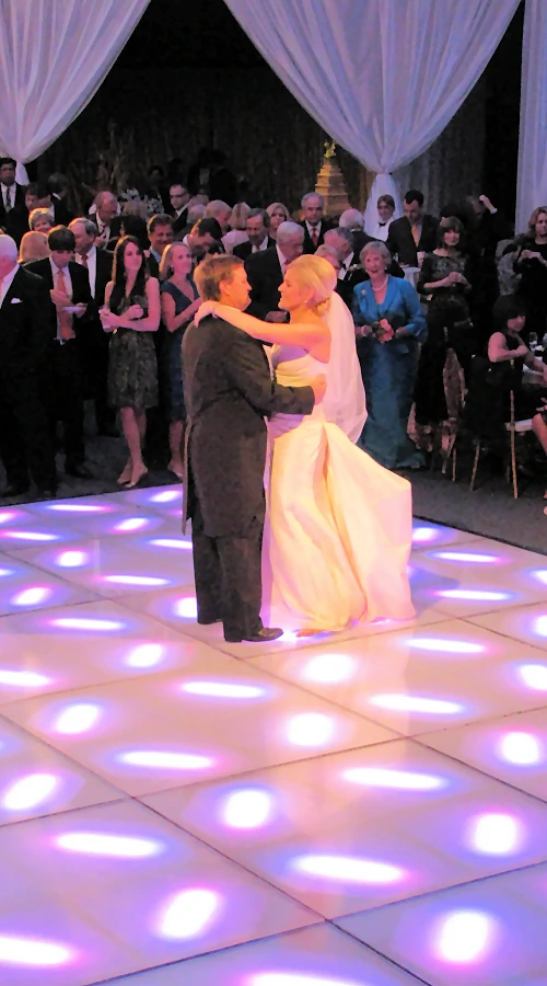 Singer on a stage with band in the background and surrounded by an 80s dance floor.